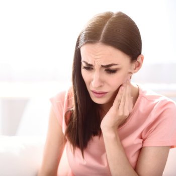Brunette woman holding cheek tooth pain Emergency Dental Care  Acworth